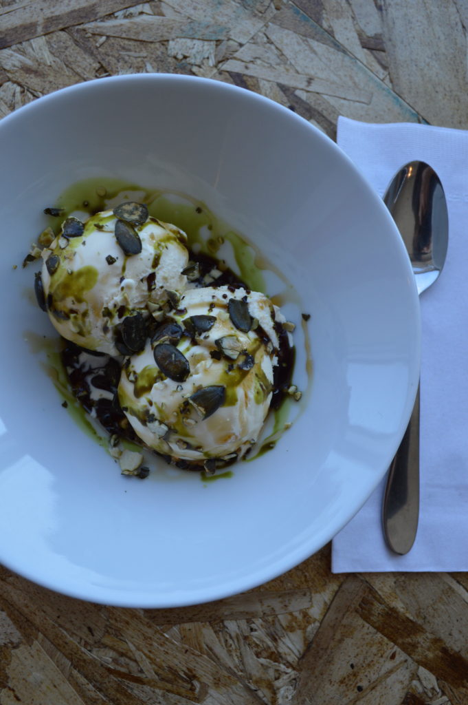 A bowl of vanilla ice cream with Styrian pumpkin seed oil and apple balsamic vinegar.