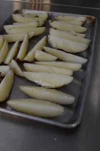 Russet potatoes cut into wedges, after being simmered in their jackets and cooled thoroughly