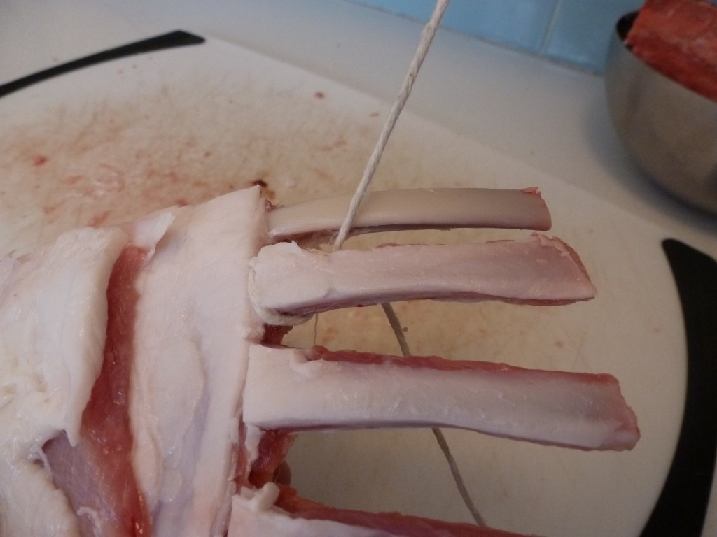 Frenching a lamb rack with a length of butcher's twine