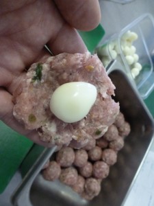 Packing hard-boiled quail eggs in forcemeat