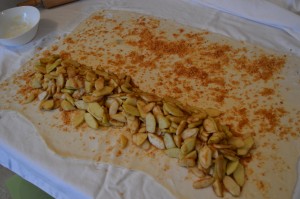Filling the strudel dough with toasted breadcrumbs and apples