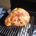Glazed ham smoking on the barbecue