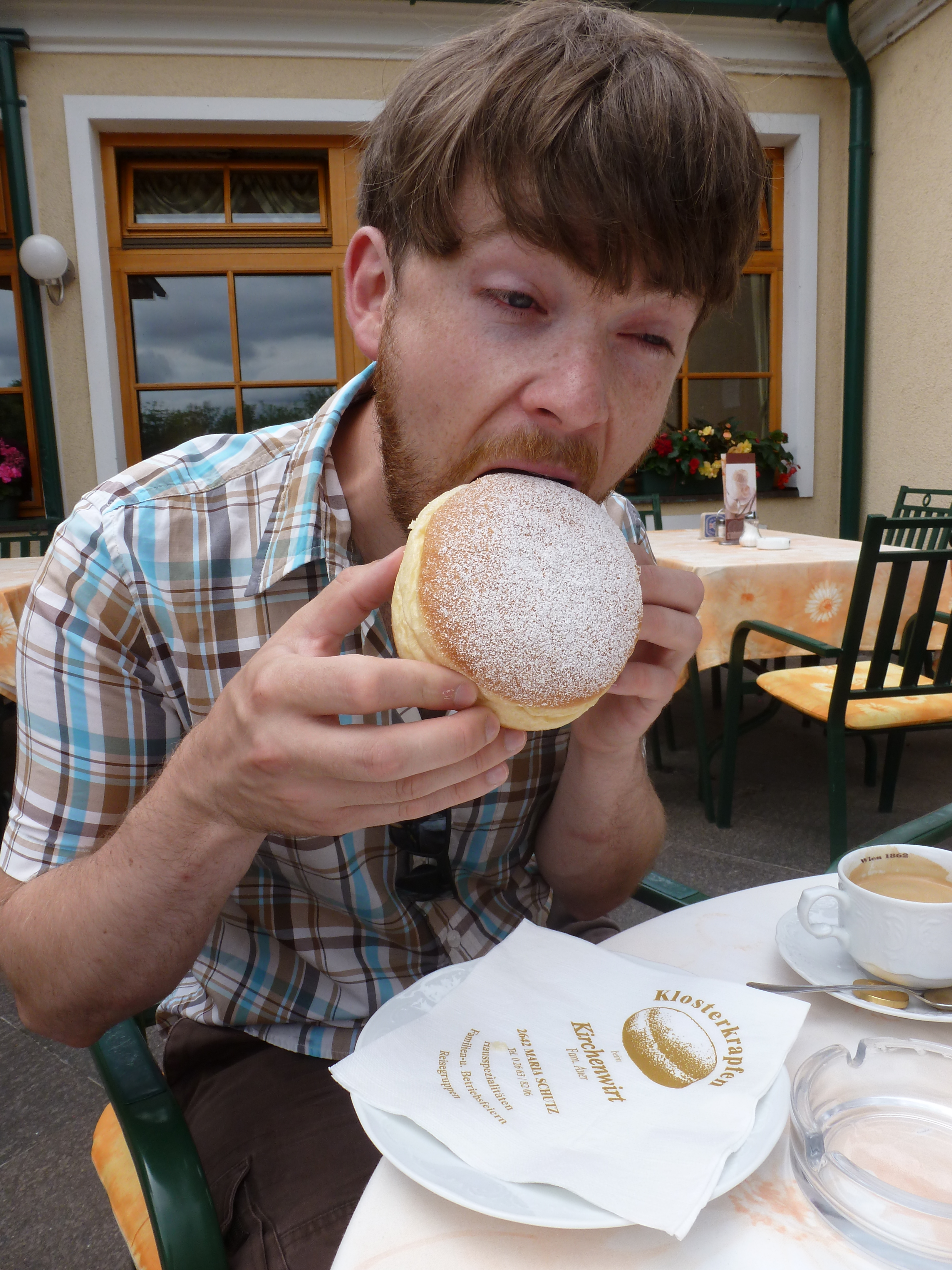 Allan wrangling a krapfen, an Austrian jelly doughnut