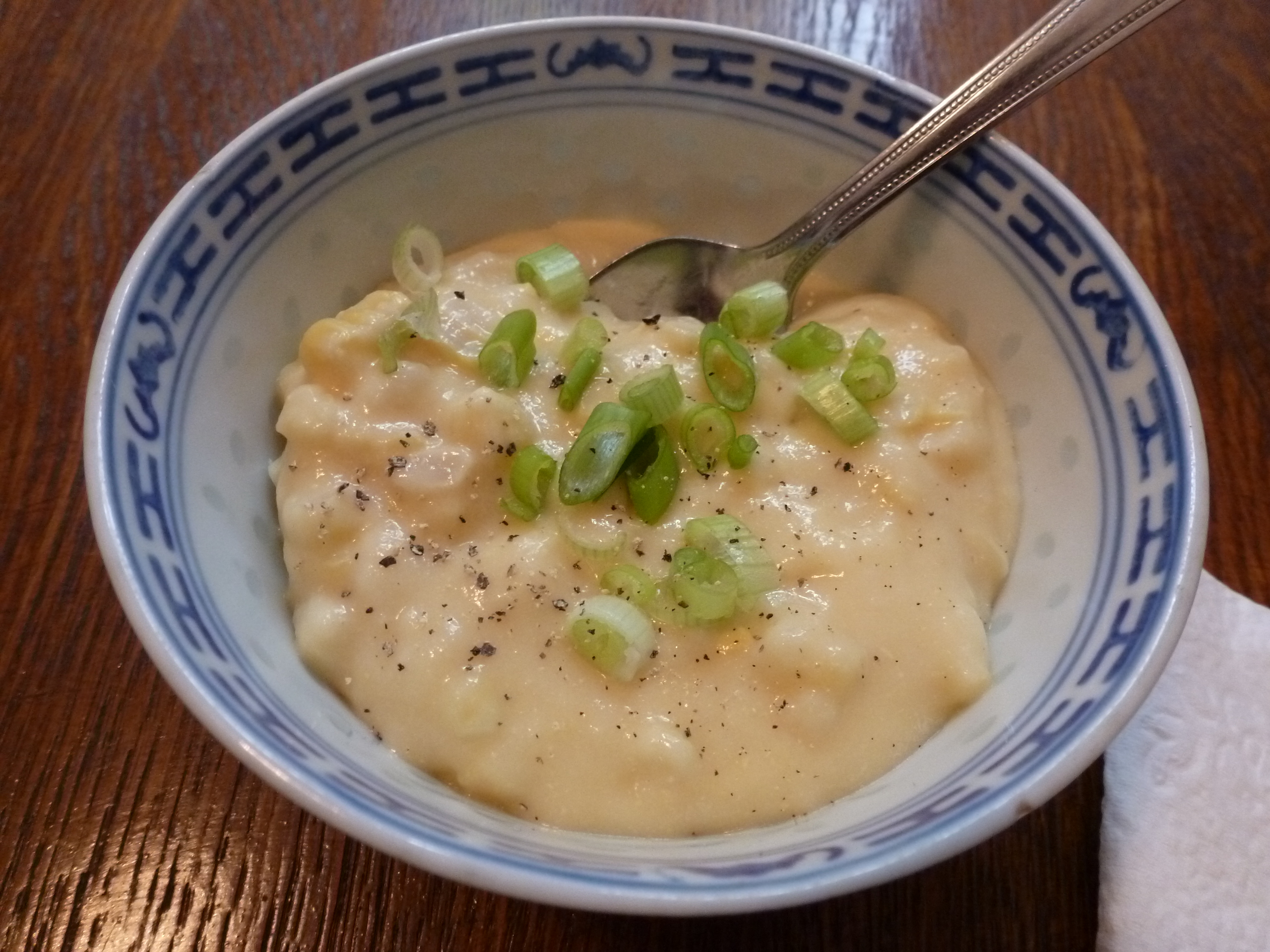 A bowl of creamed corn with green onions