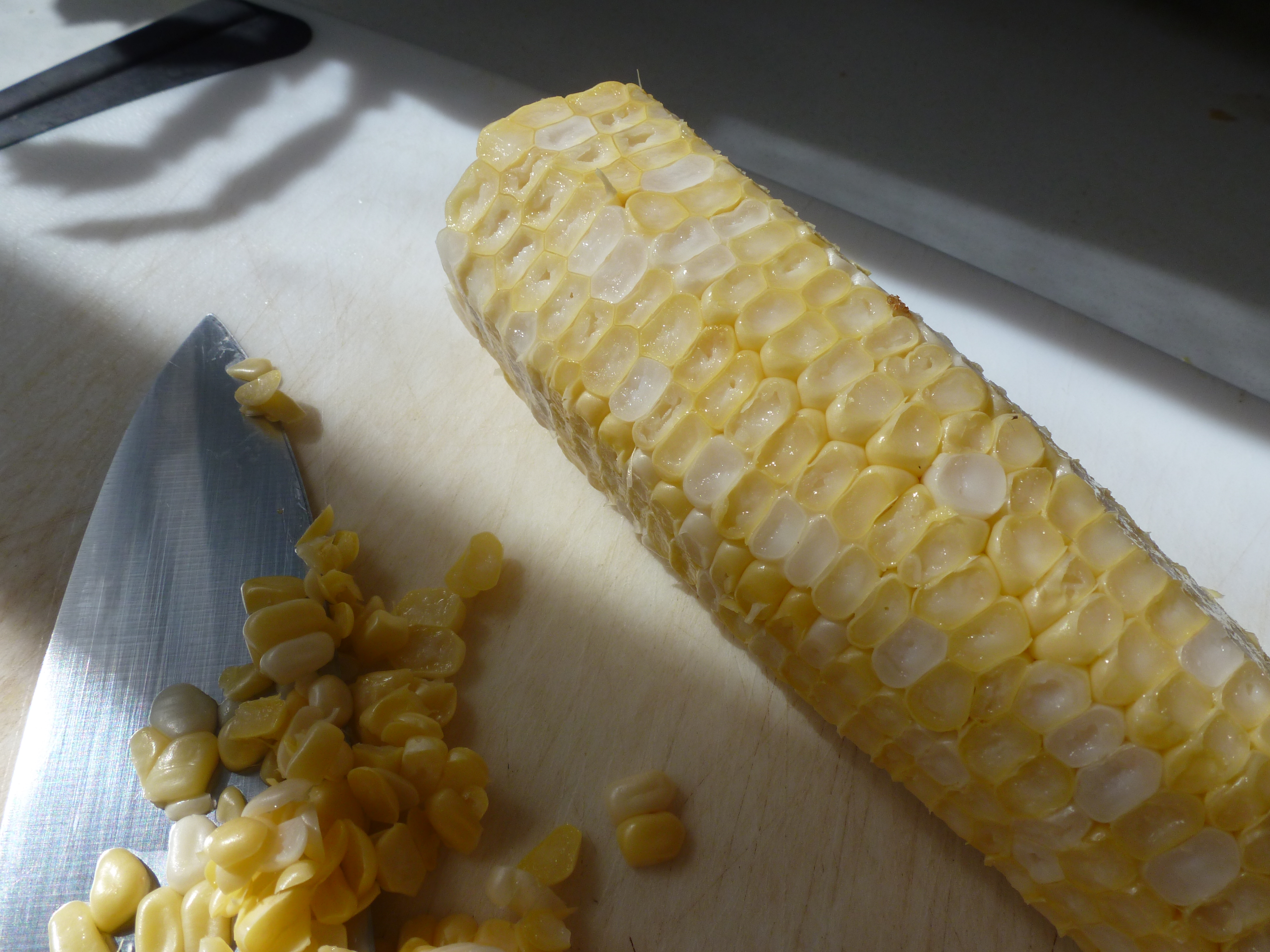 Cutting the tips of the corn kernels to expose the interior