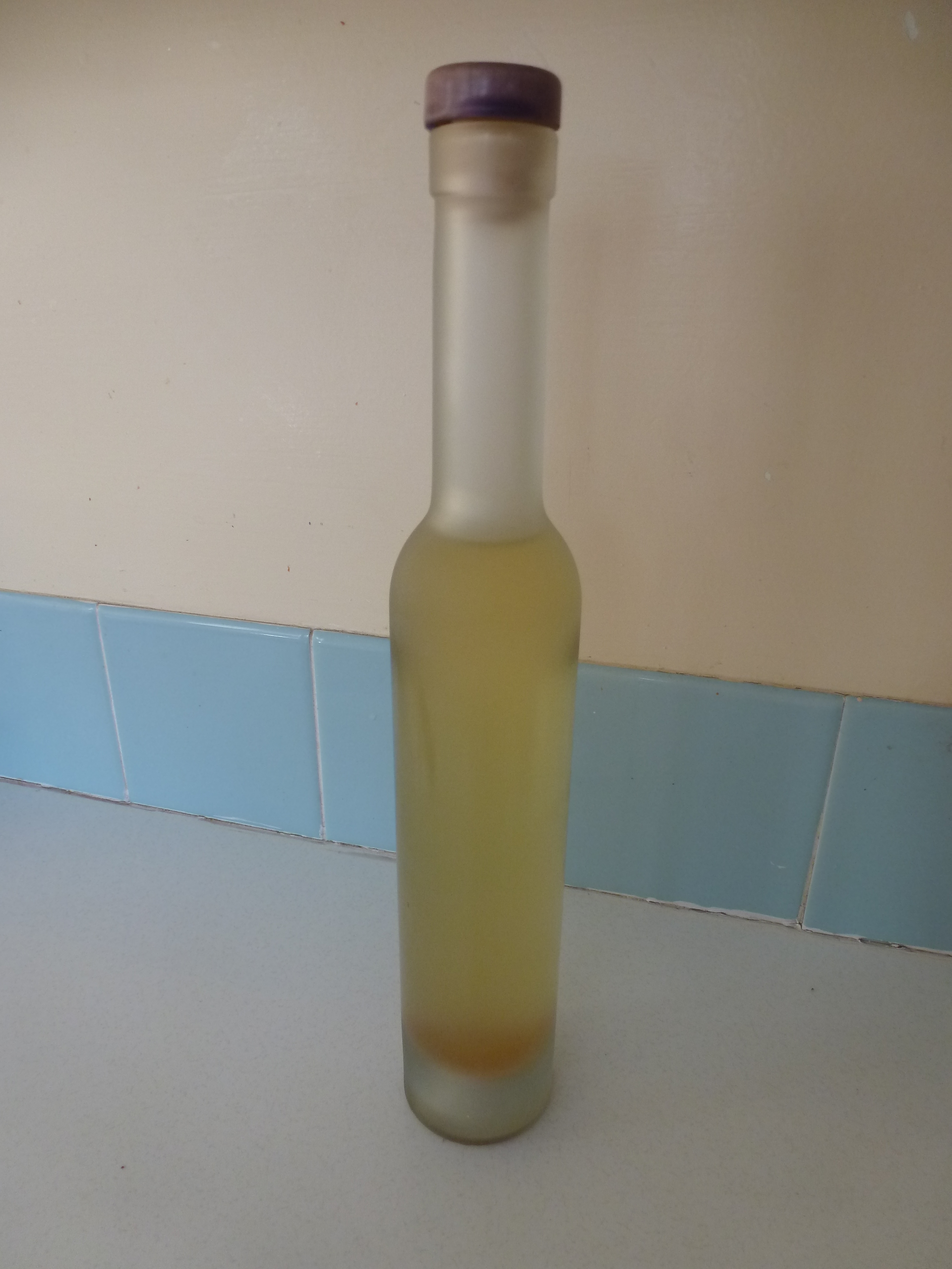 A bottle of honey-coloured homemade cider vinegar.