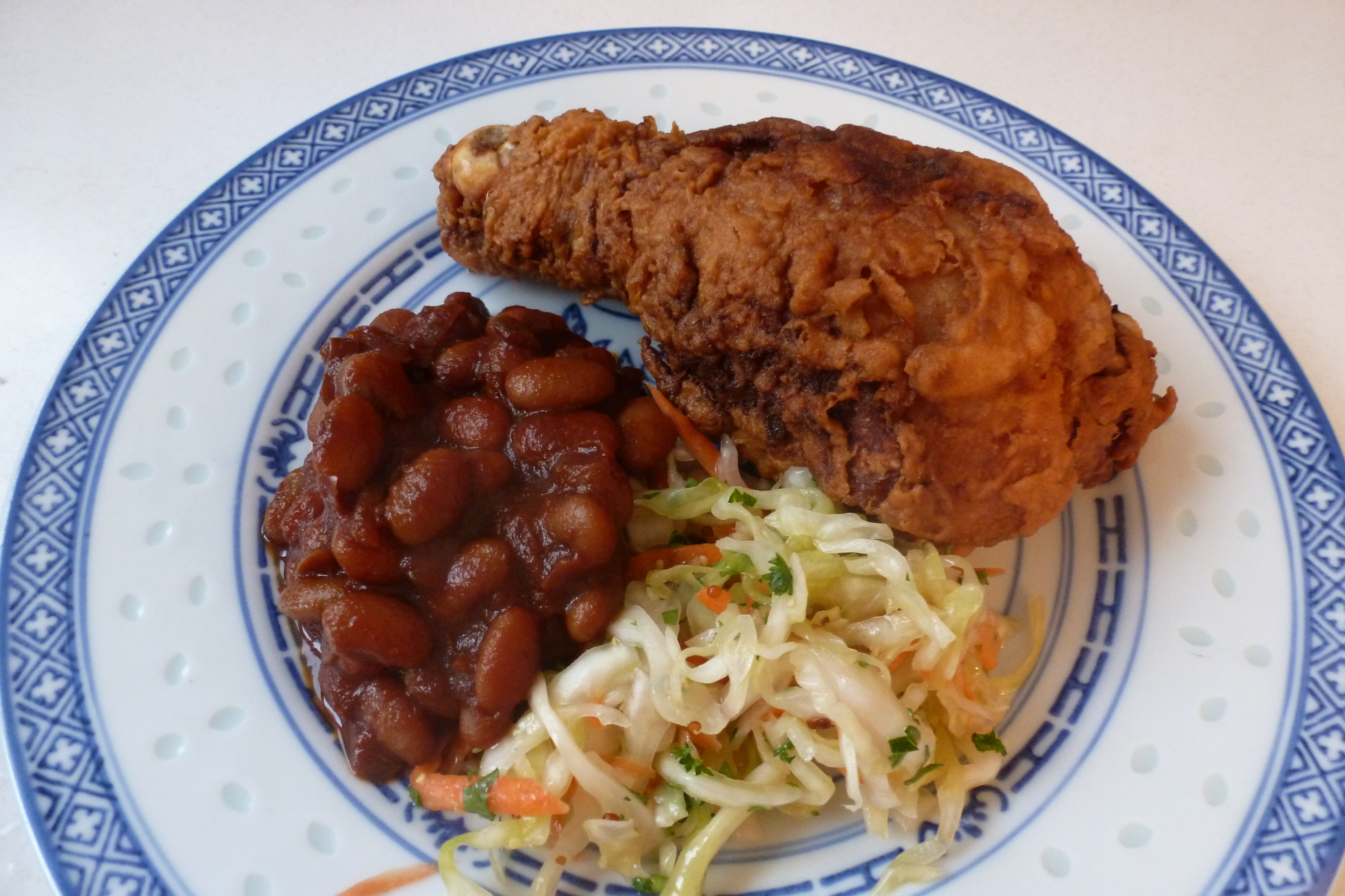 Fried chicken drumstick, brown beans, and slaw