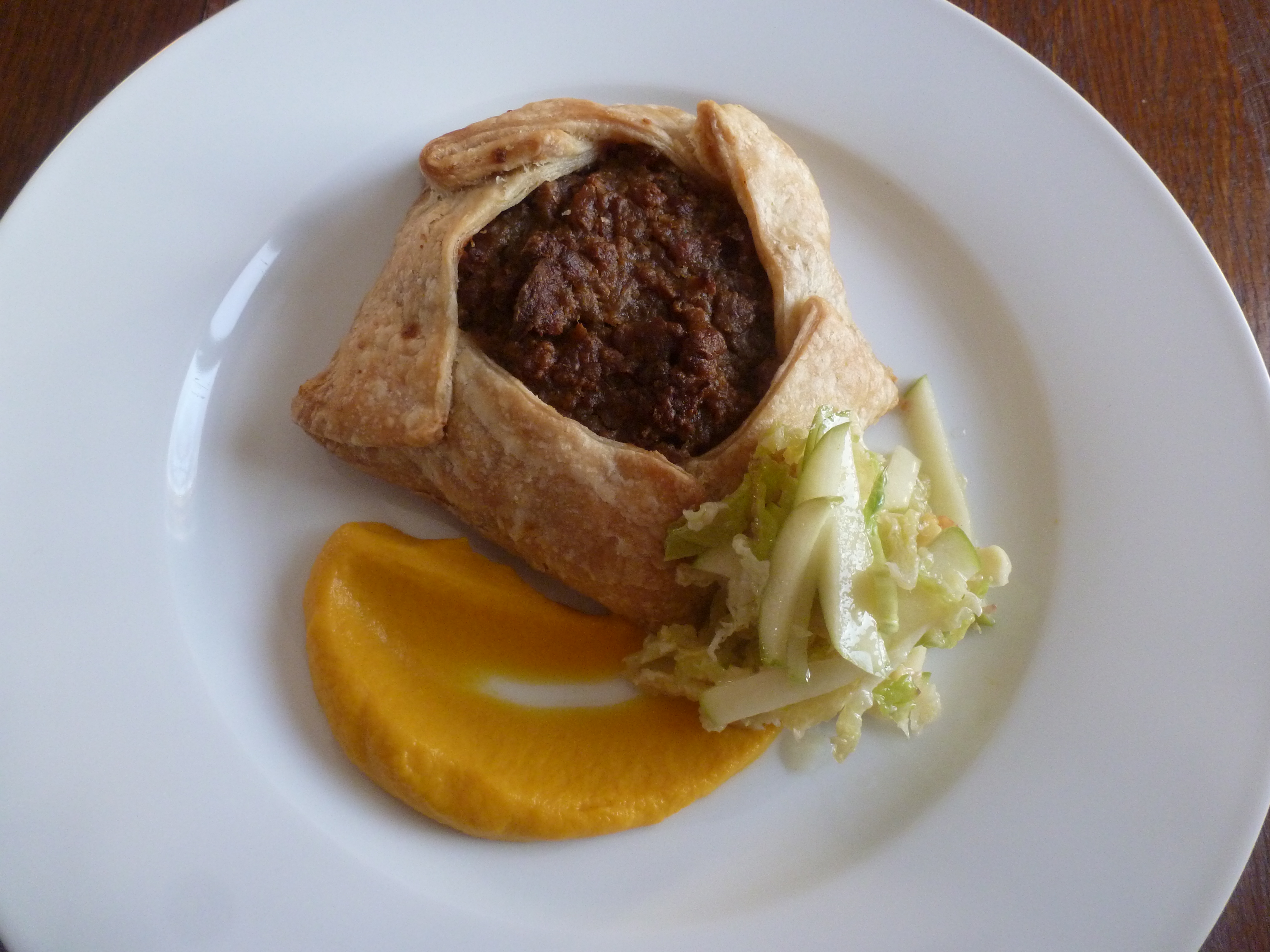 An individual tourtière, with pumpkin purée and Savoy cabbage