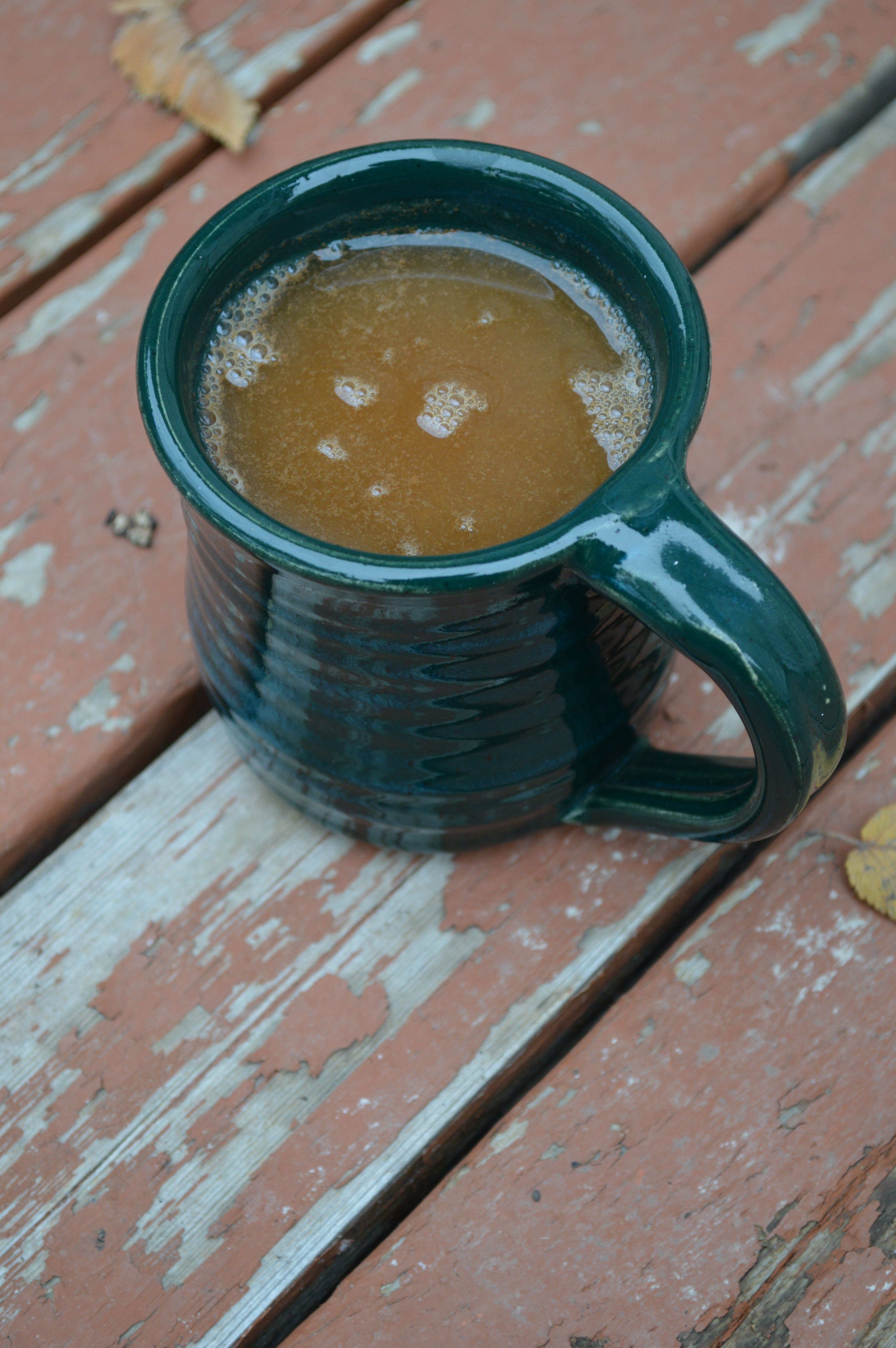 A mug of frothy, steaming mulled cider.