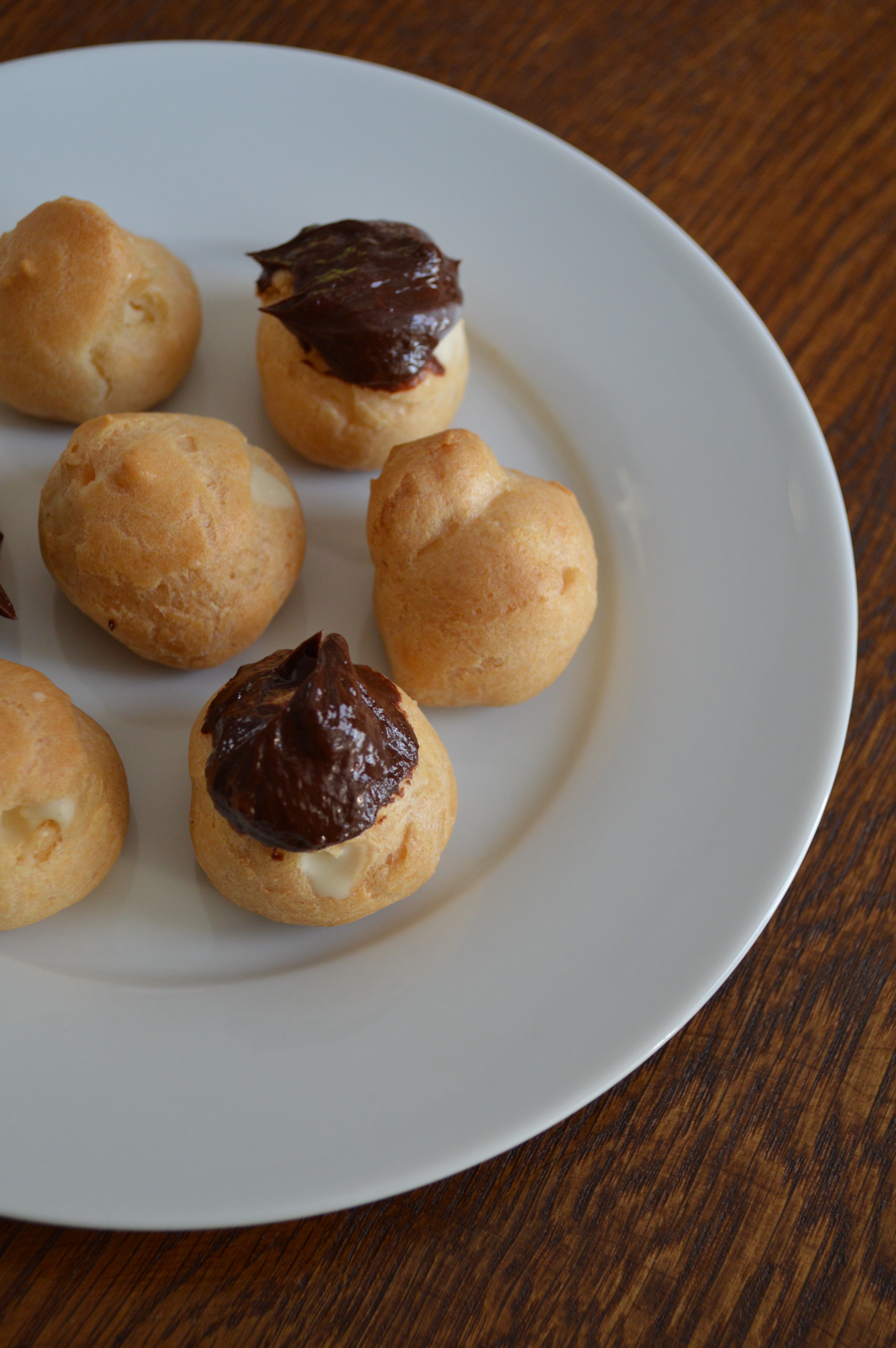 Cream puffs, some dipped in chocolate