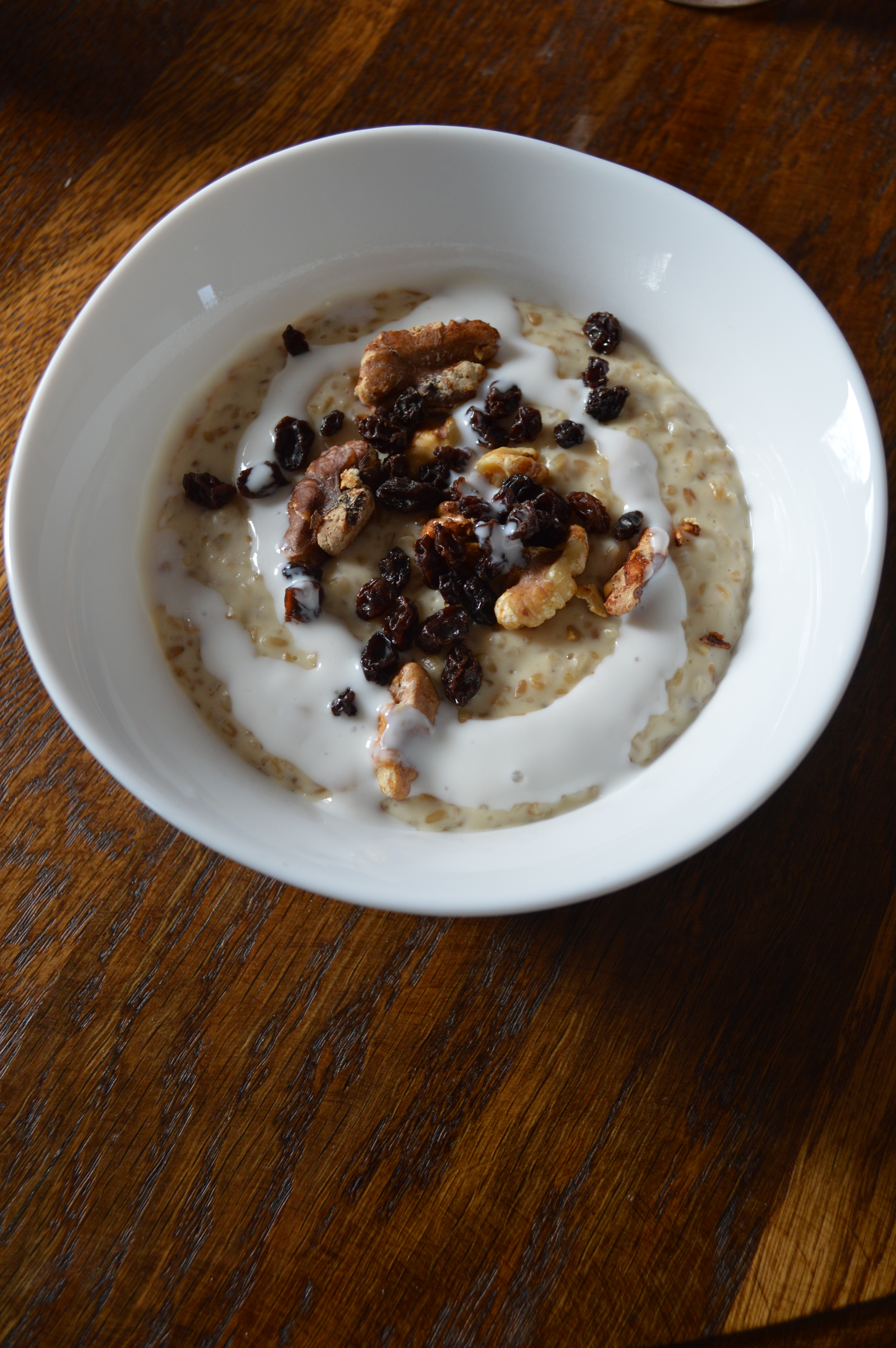 A bowl of porridge with walnuts, dried currants, and buttermilk