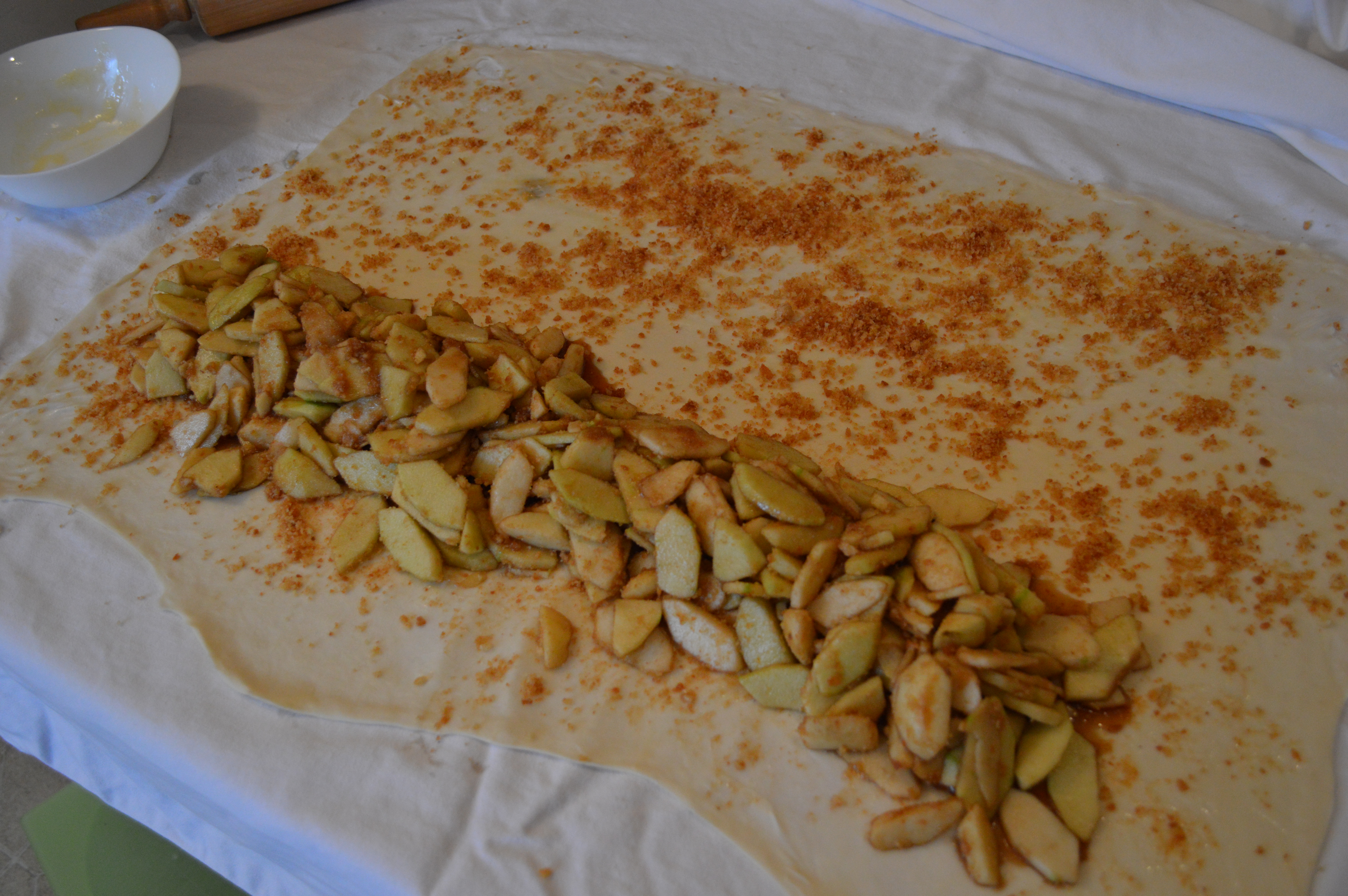 Filling the strudel dough with toasted breadcrumbs and apples