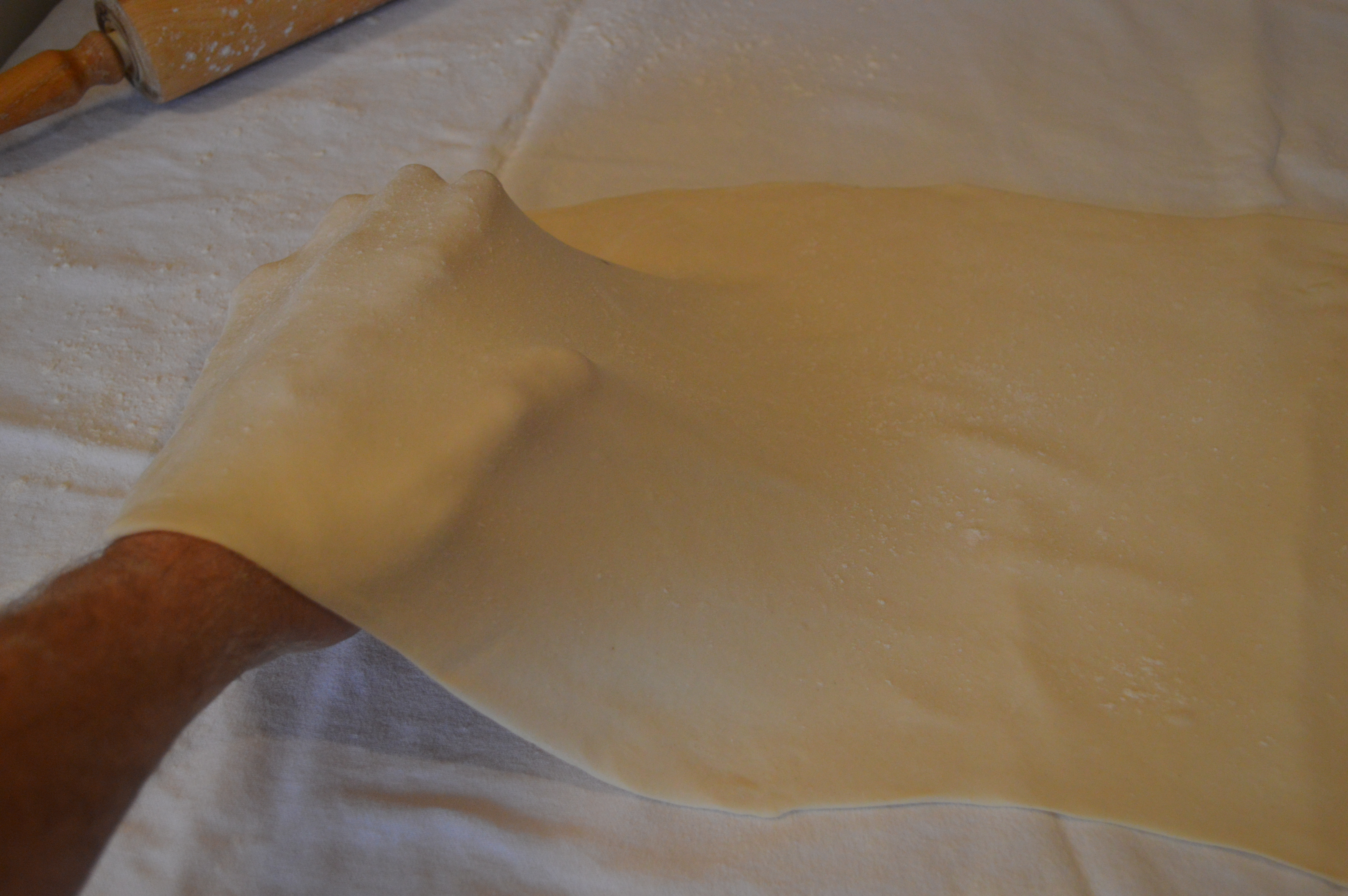 Stretching traditional Austrian strudel dough by hand.