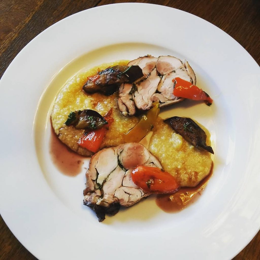 Braised rabbit with polenta, eggplant, and bell pepper.