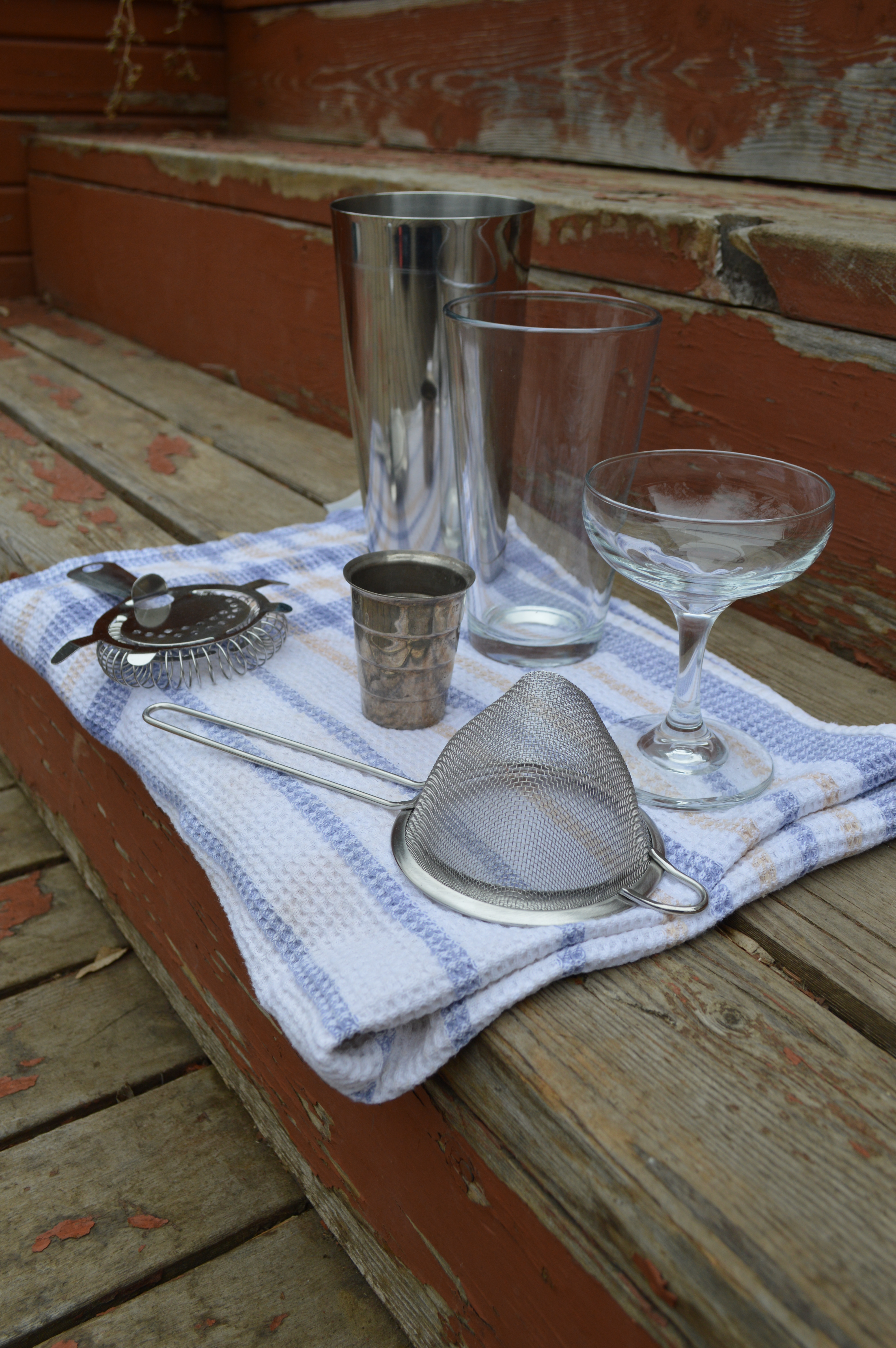 The equipment required for making a shaken cocktail: Boston shaker, Hawthorne strainer, and fine mesh strainer.