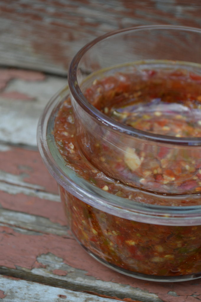 Fermenting chili paste using the submersion method: weighing down the ingredients so they stay submerged in their own brine.